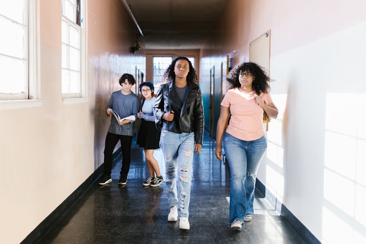 services-03 A diverse group of teenagers walking confidently in a school hallway, showcasing youth and diversity.